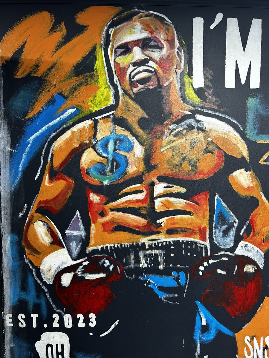 Hand-painted mural of a celebratory boxer with raised arms and 'EST. 2023' text, marking DogHouse's founding